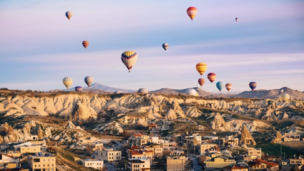 colorful-hot-air-balloons-flying-city-cappadocia-turkey-volcanic-mountains-goreme-national-park-morning-scaled